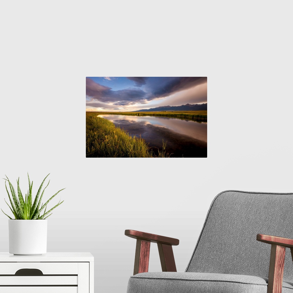 A modern room featuring Landscape photograph of a river in the valley reflecting the cloudy sky.