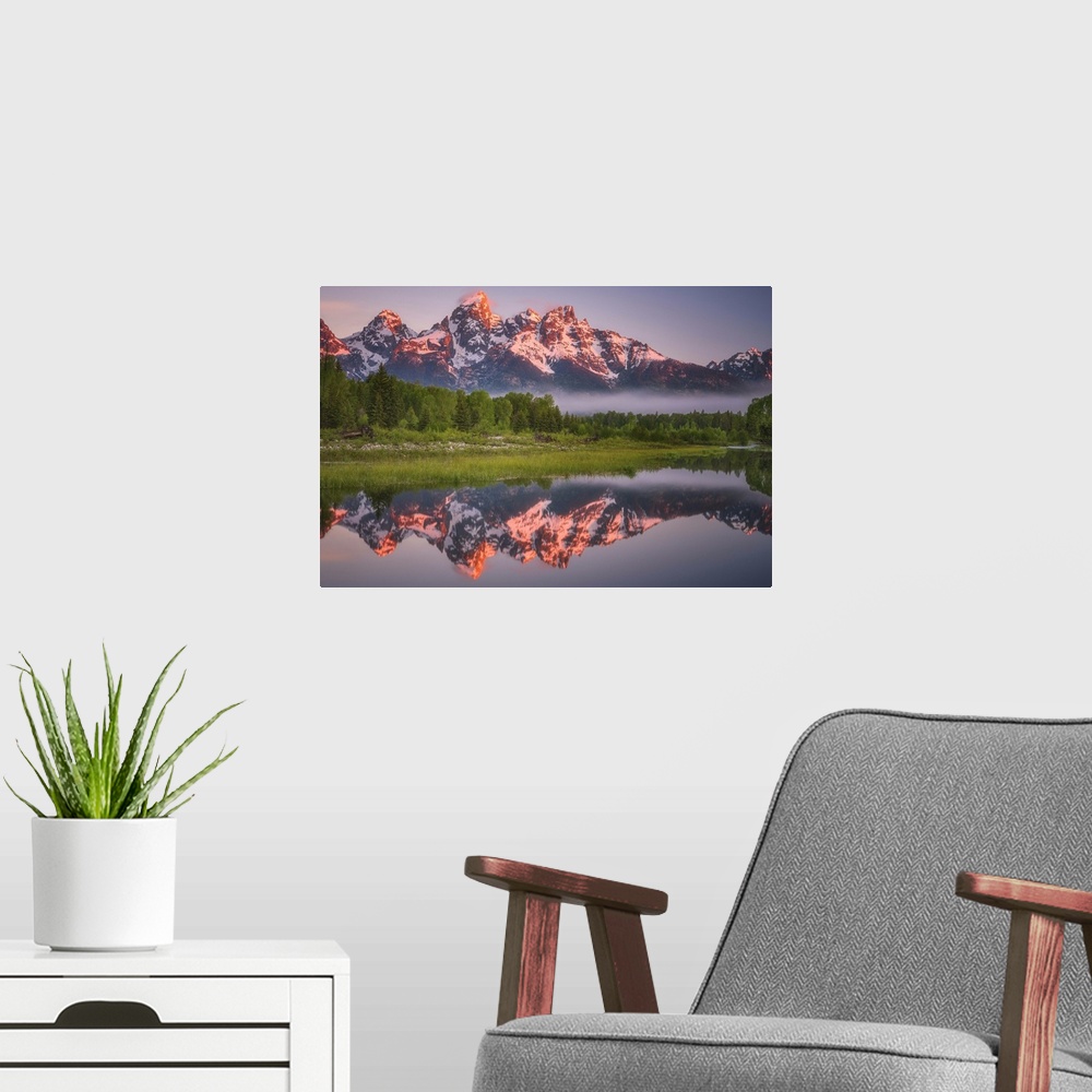 A modern room featuring Bright sunlight on the peaks of the Grand Teton mountains.