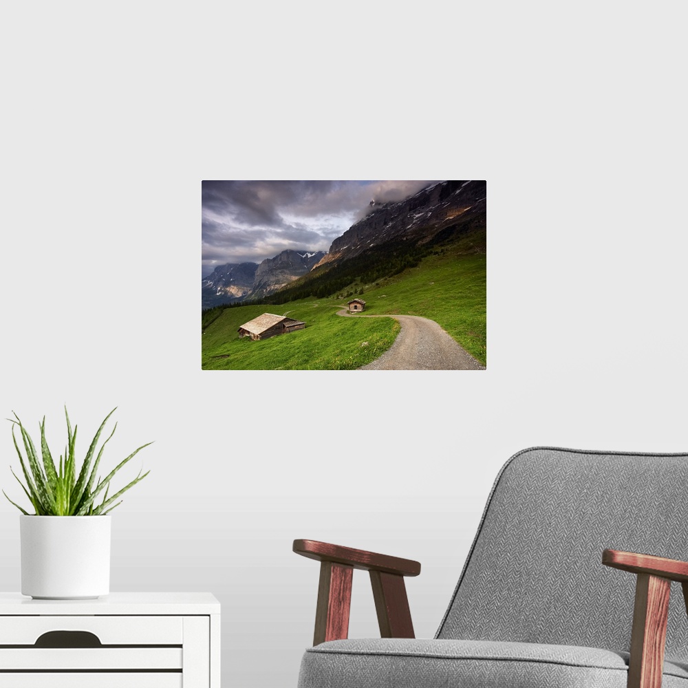 A modern room featuring A photograph of the roof of a cottage in a dreary mountainous valley landscape.