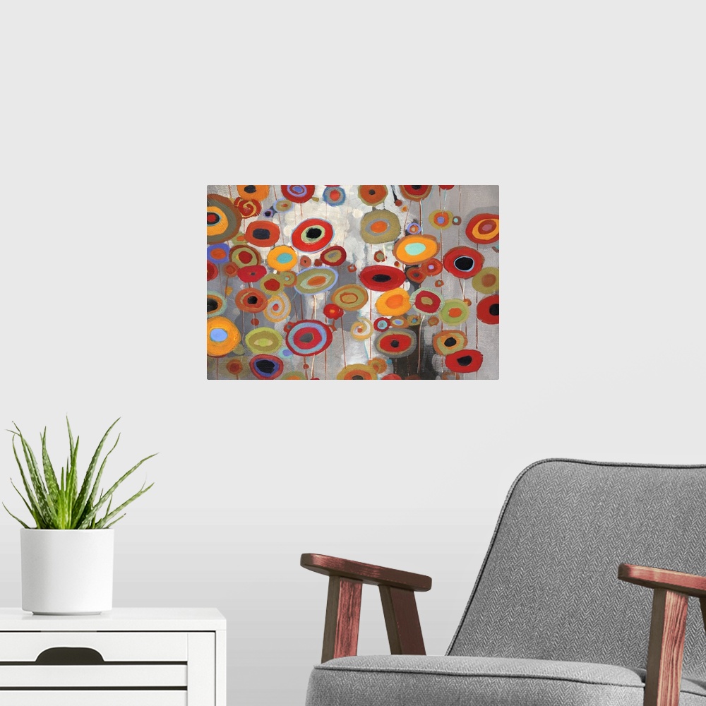 A modern room featuring A horizontal abstract of bright multi-colored flowers on a neutral backdrop.