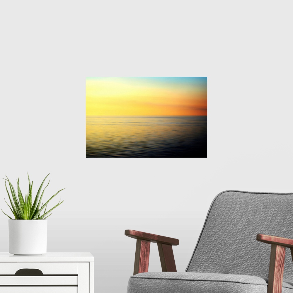 A modern room featuring Horizontal image of a color sunset over calm ocean waters.