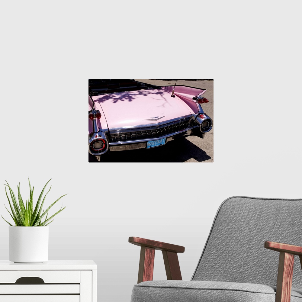 A modern room featuring Classic 1959 pink Cadillac convertible on road in beautiful Varadero Beach in Valadero Cuba