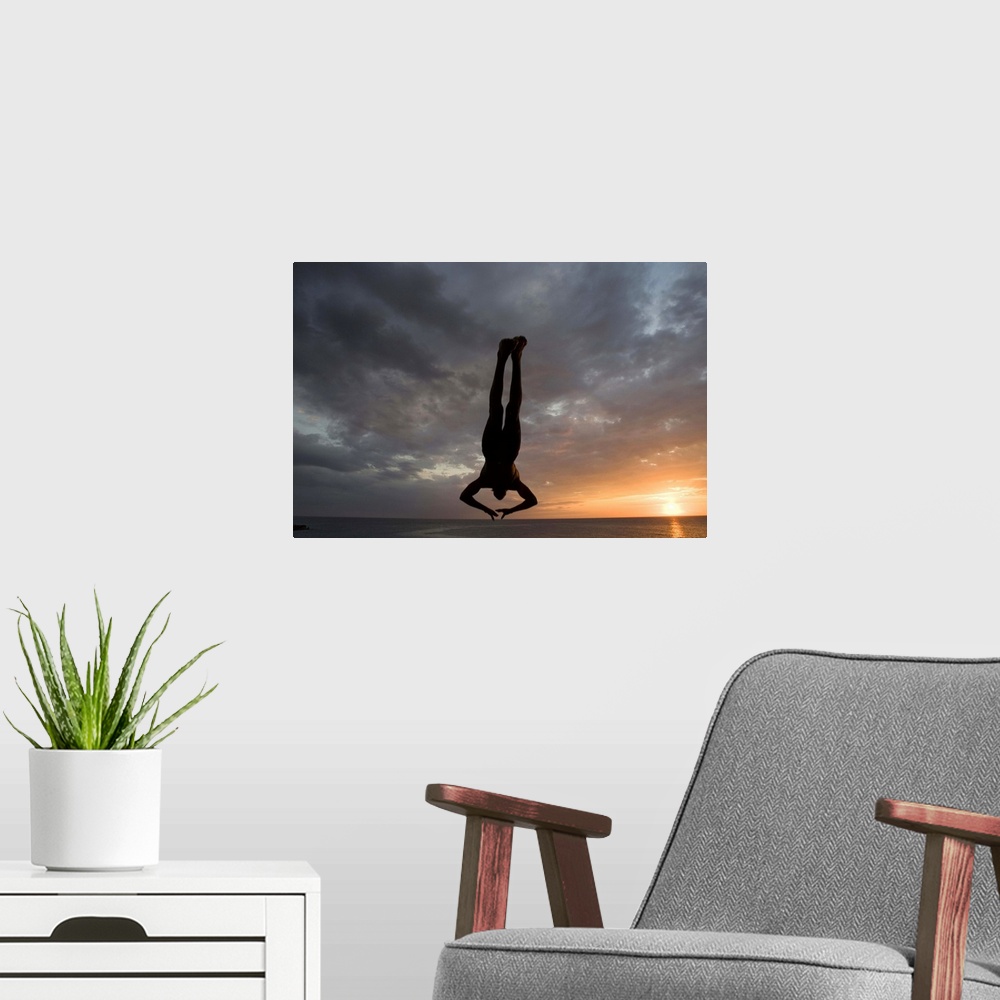 A modern room featuring Jamaica, Negril, Silhouette of young man leaping from from cliff above Pirates Cave