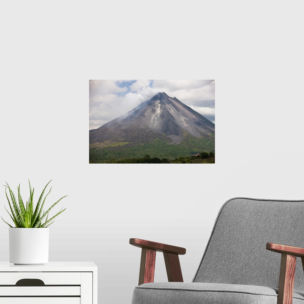 A modern room featuring Lava rocks are thrown from the erupting Arenal volcano to the mountainside and forest below in Ar...