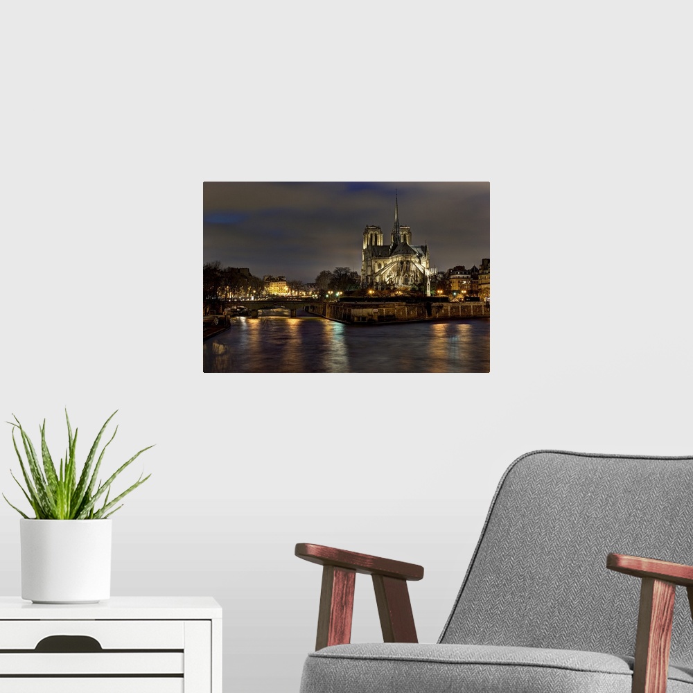 A modern room featuring Notre dame cathedral and the seine river shimmer in the Paris, France. Night.