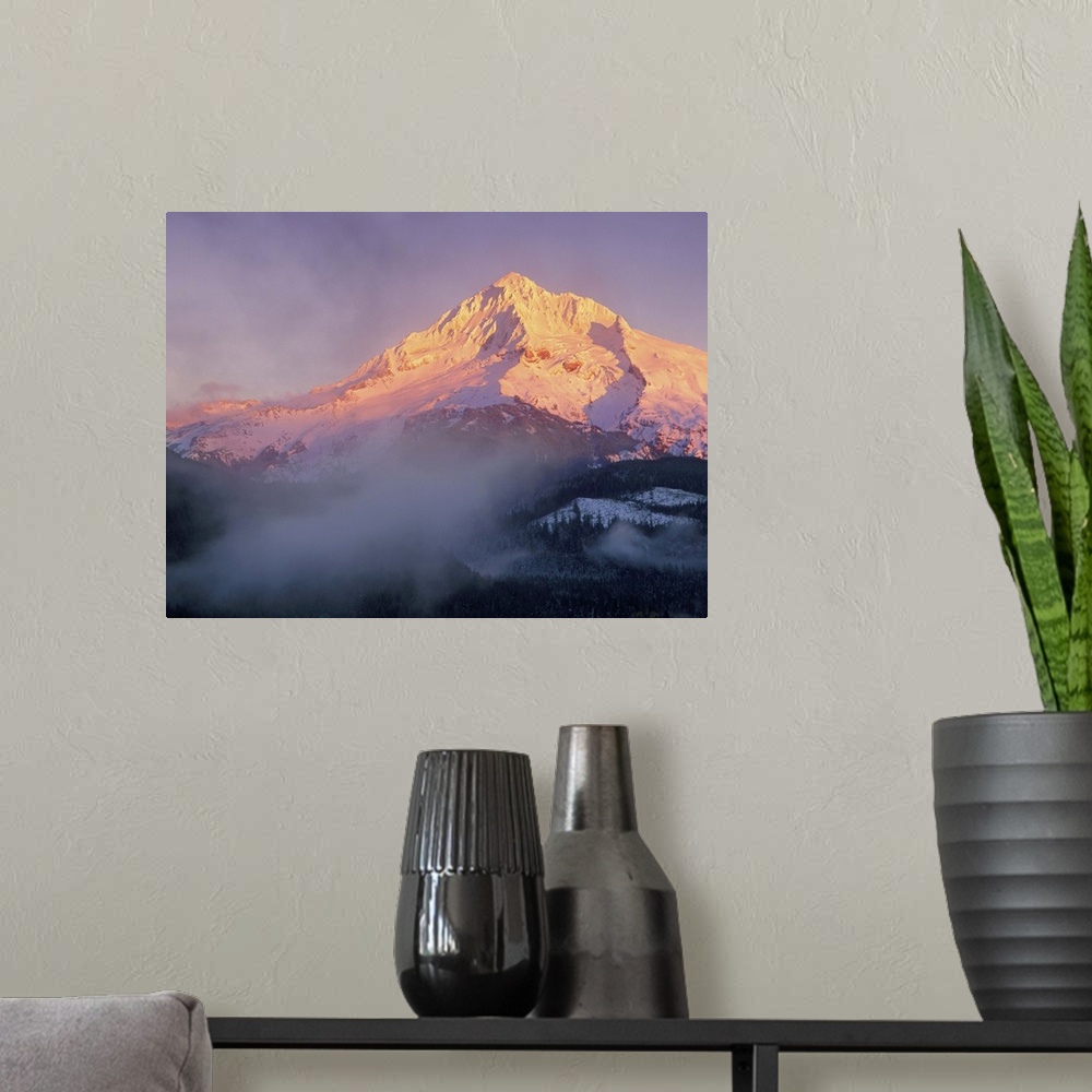 A modern room featuring Sunset colors the slopes of Mt Hood, Oregon, as clouds and fog sit in the valley.