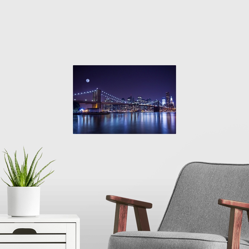 A modern room featuring New York City's Brooklyn Bridge at night under a full moon.