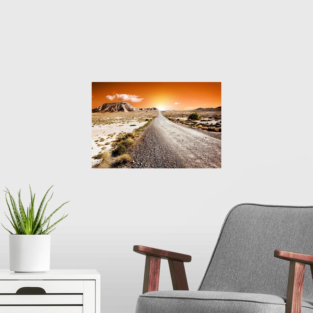 A modern room featuring Sunset desert landscape with road.