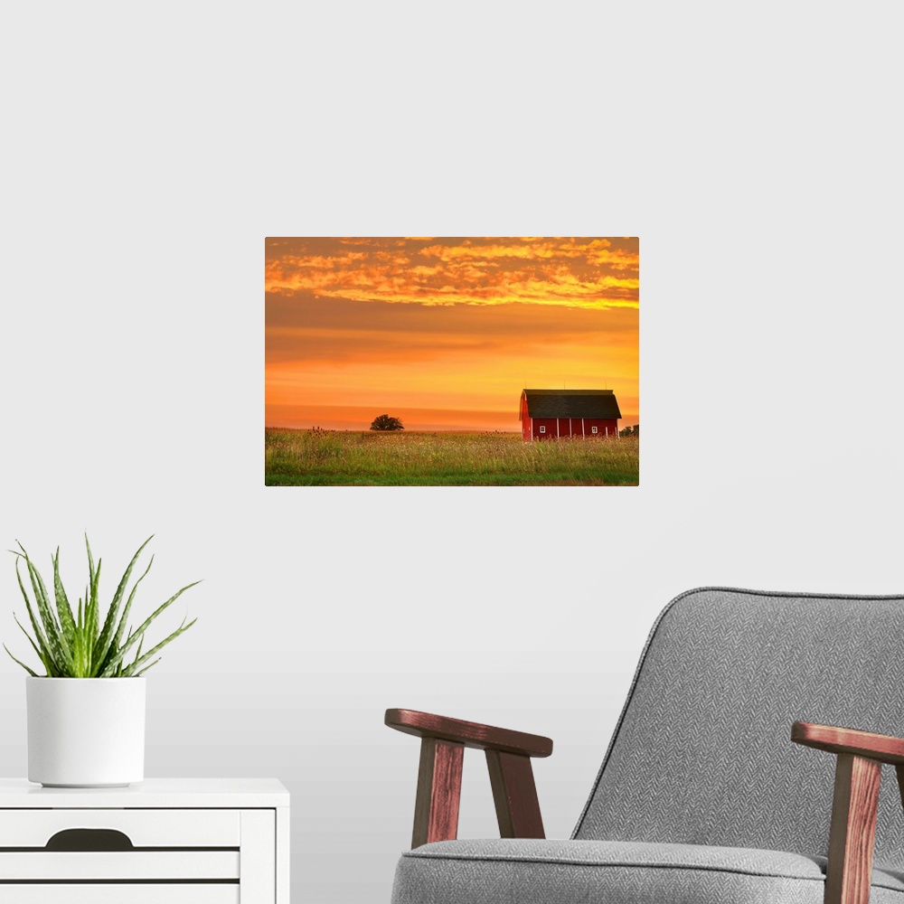 A modern room featuring Farm landscape with old barn against bright evening sky.