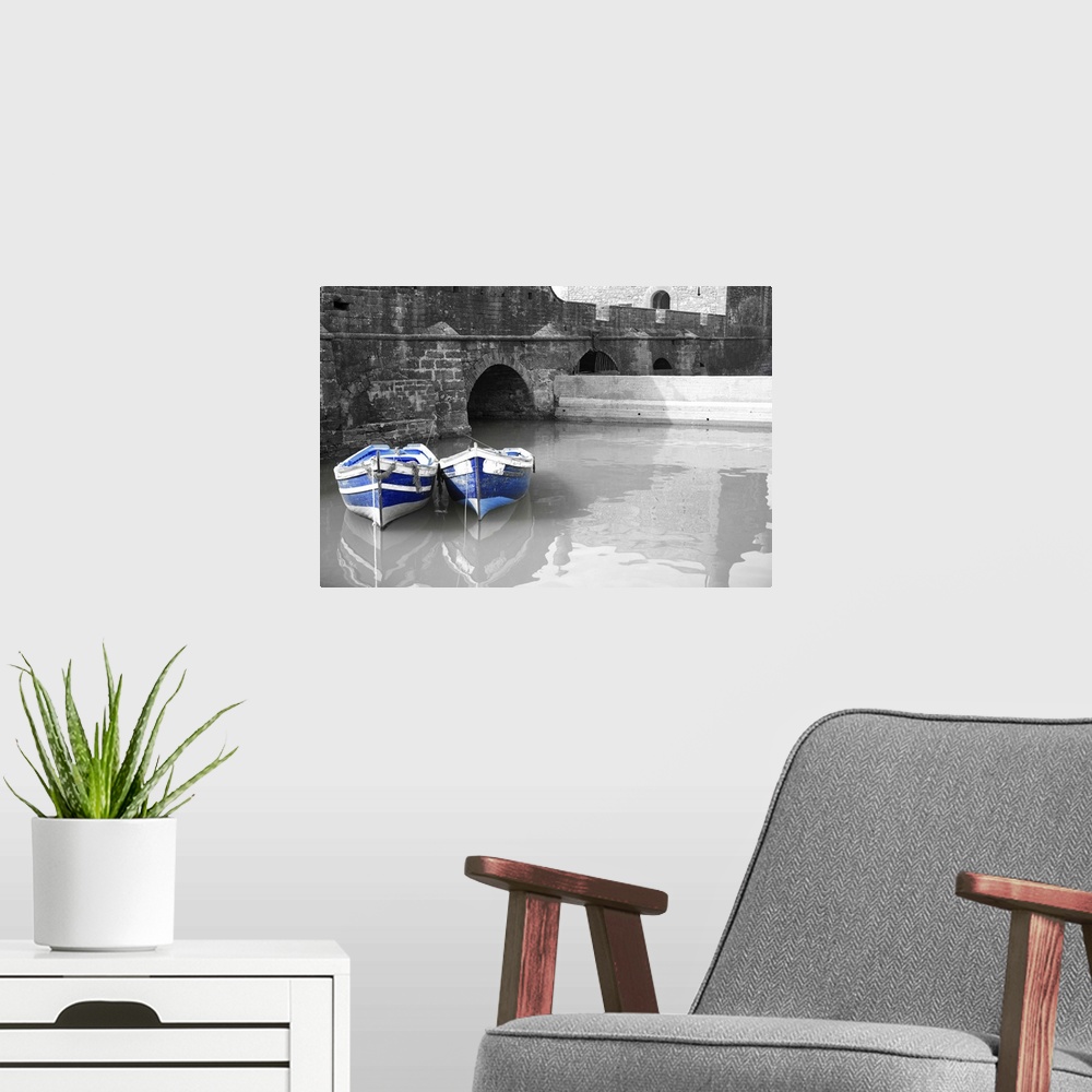 A modern room featuring Black and white harbor with two blue boats in Essaouria, Morocco.