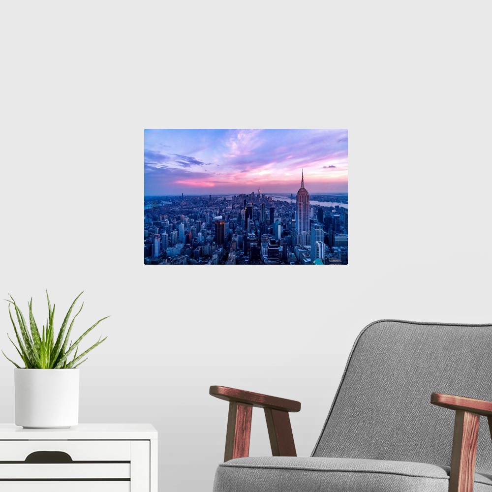 A modern room featuring USA, New York City, Manhattan, Empire State Building, dramatic pink sky and light over Manhattan.