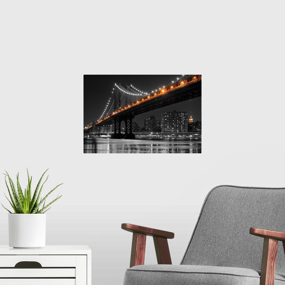 A modern room featuring Black and white photograph of the Manhattan Bridge at night with only the lights in color.