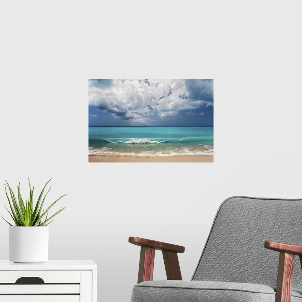 A modern room featuring Landscape photograph of the ocean's crashing waves onto the shore on a beautiful day.