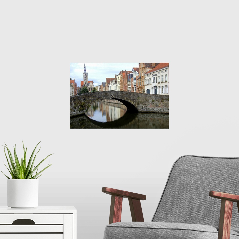 A modern room featuring Photograph of an old stone bridge in Belgium over a river.