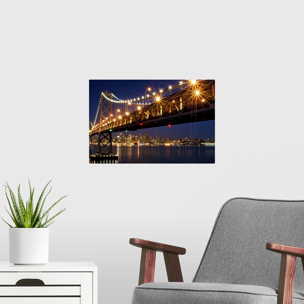 A modern room featuring A burst of lights on the Bay Bridge and San Francisco skyline in the background.