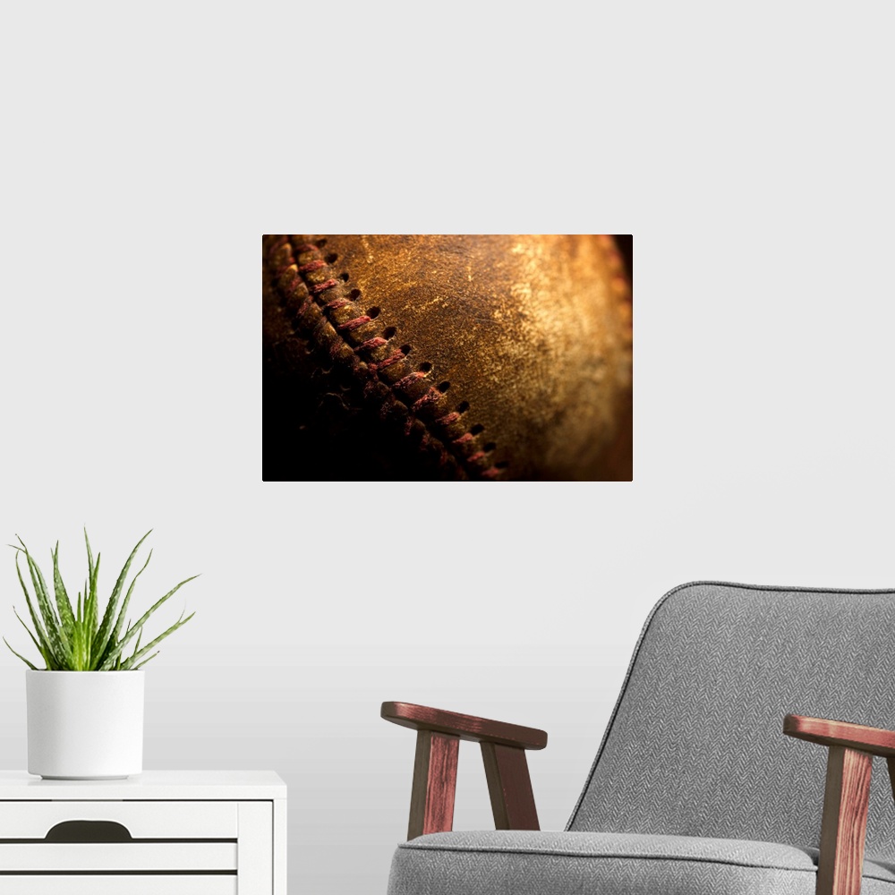 A modern room featuring A closeup of an old baseball. Shot with shallow depth of field.