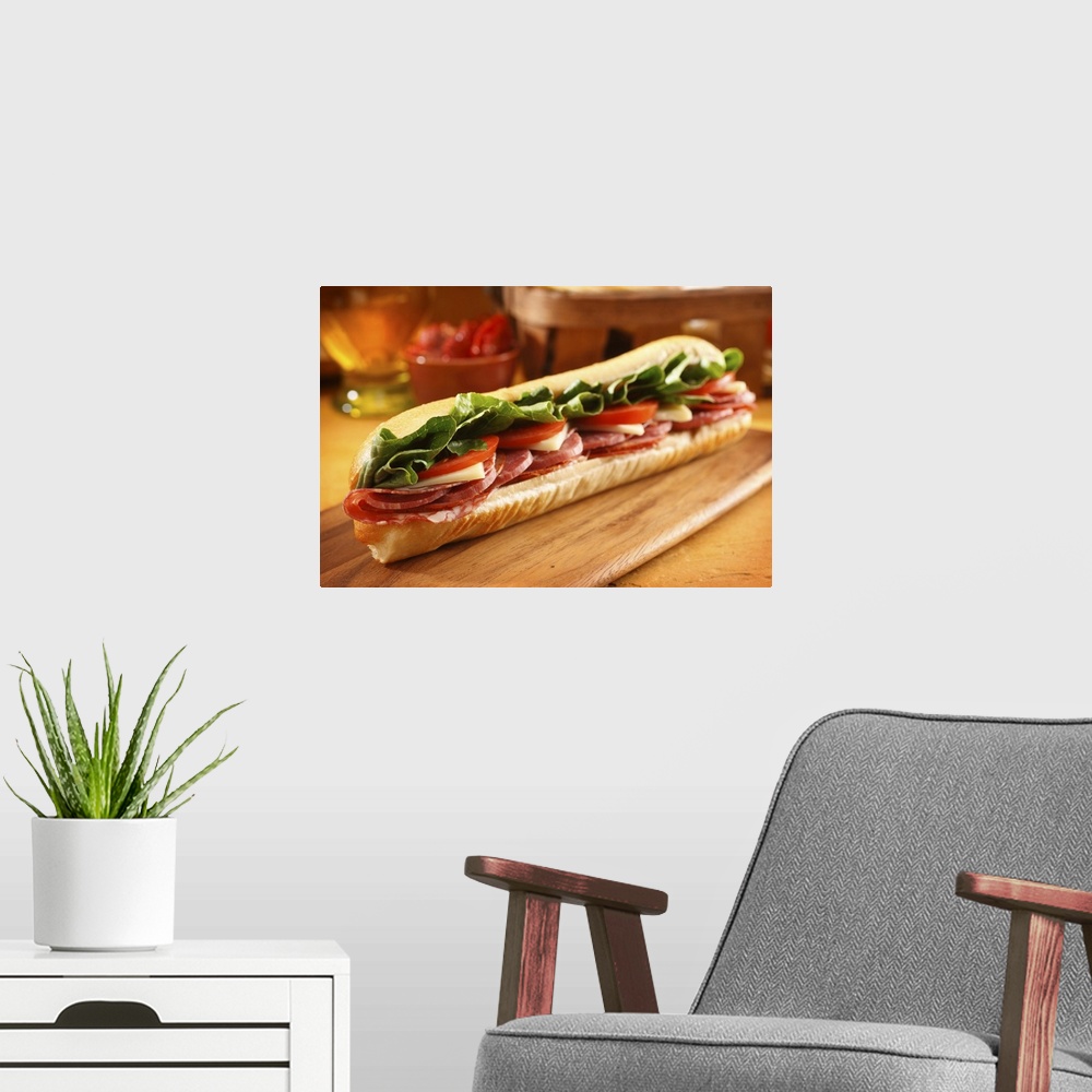 A modern room featuring An Italian sub sandwich with ham,salami,pepperoni, Swiss cheese, lettuce and tomato on a sandwich...