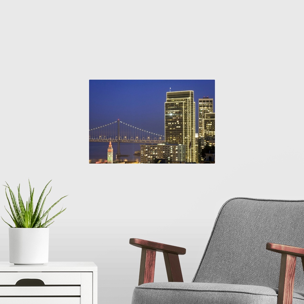 A modern room featuring Holiday lights are on downtown buildings, bay bridge and Ferry building in San Francisco.