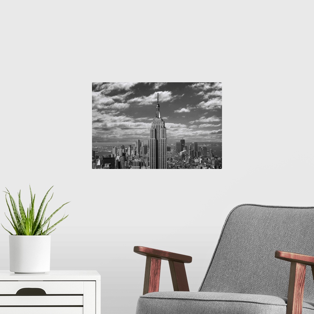 A modern room featuring Black and white landscape photograph taken of the Empire State building with the skyline seen in ...
