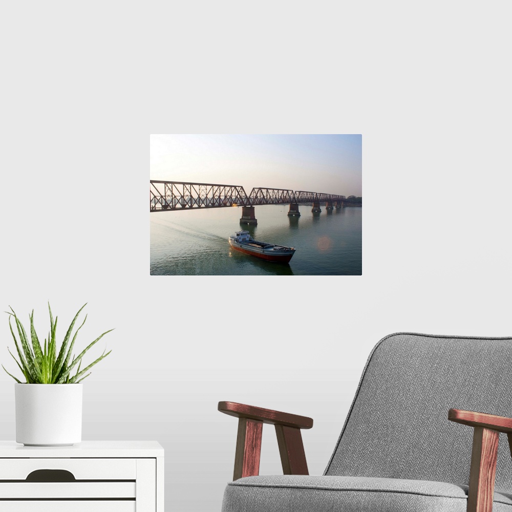 A modern room featuring Boat passing from under bridge in river at Narshingdi, Bangladesh.