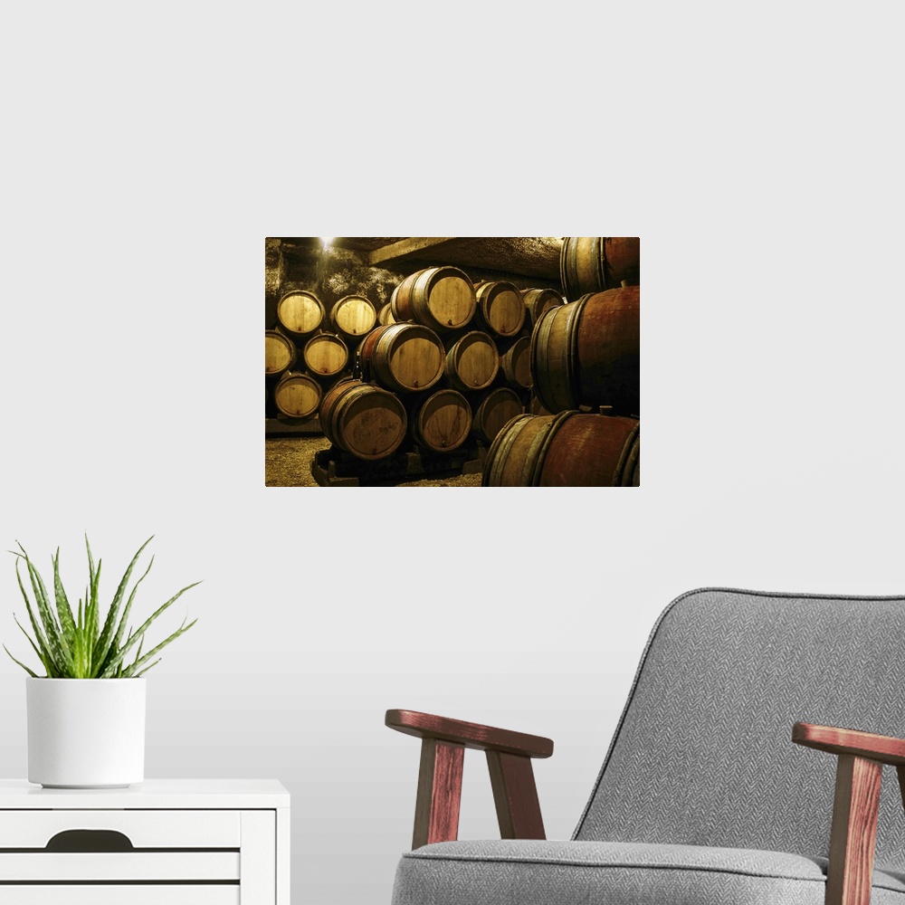 A modern room featuring Photograph of a cellar or basement full of barrels in storage stacked on top of one another. A si...