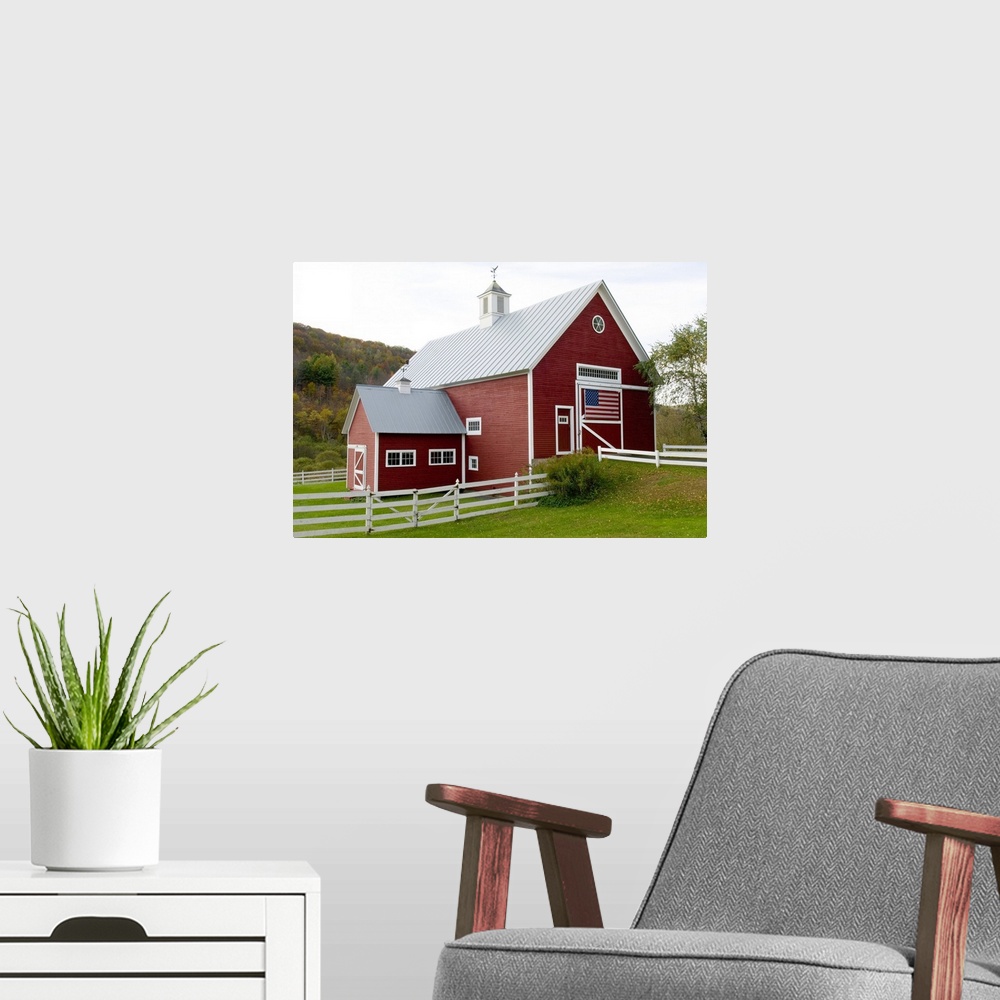 A modern room featuring Classic New England farm with red barn and white fence. American flag on barn door. Vermont. USA