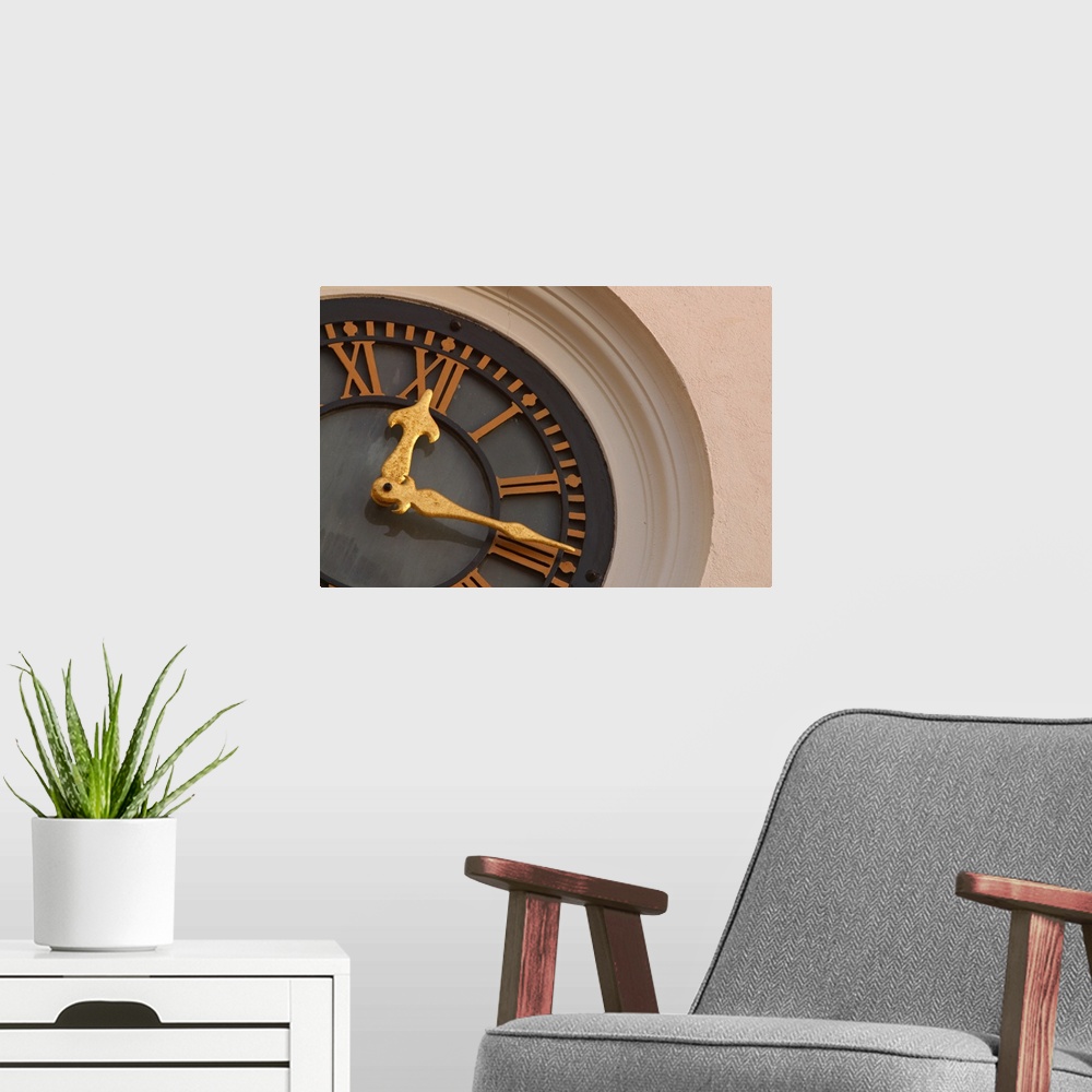 A modern room featuring Landscape, large, close up photograph of a partial clock on a tower.  The large golden hands of t...