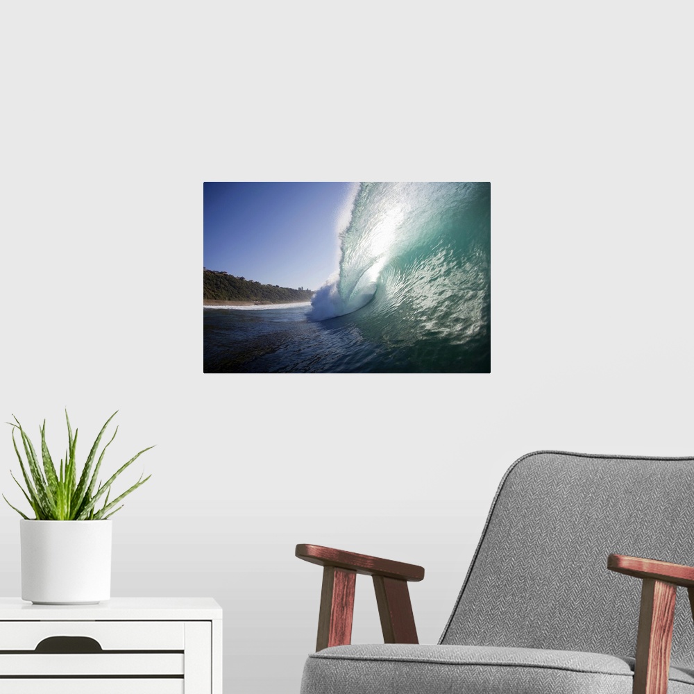 A modern room featuring Outdoor photo of a wave curling up and breaking over towards the beach on a sunny day.