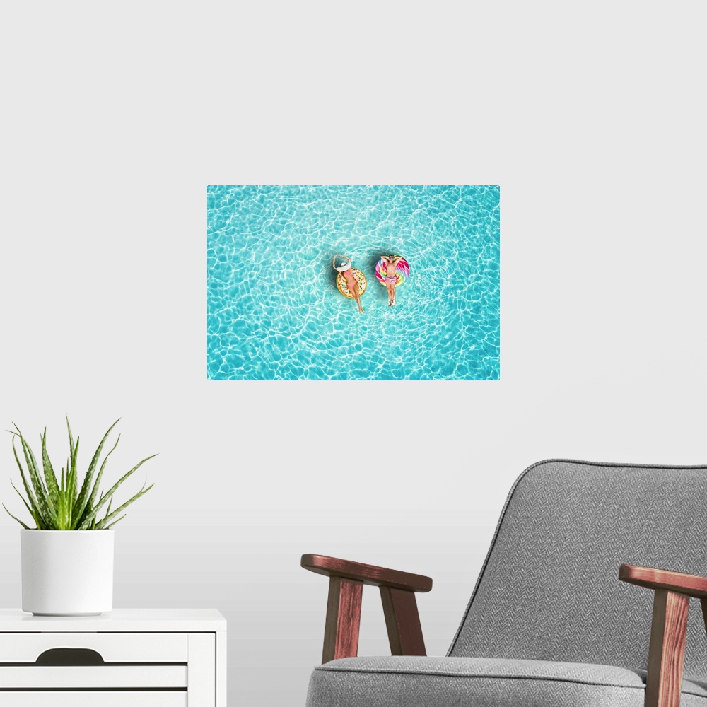 A modern room featuring A happy vacation couple in swimsuits enjoys the tropical sun of the Maldives on colorful floats o...