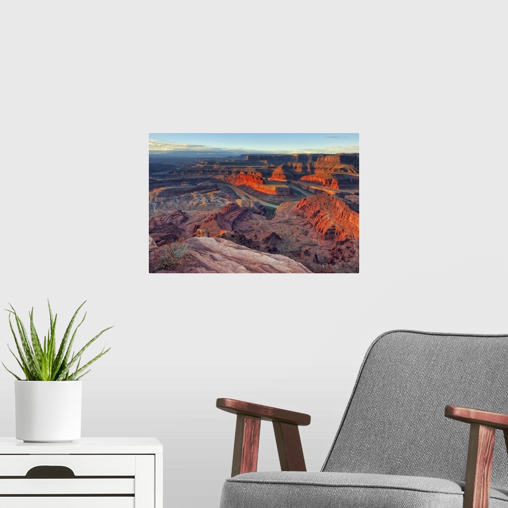 A modern room featuring Large photo on canvas of red rock formations in Utah bathed in sunlight from a rising sun.