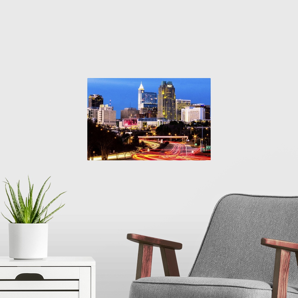 A modern room featuring Blue hour in downtown Raleigh, North Carolina, with light trails of traffic in the foreground and...
