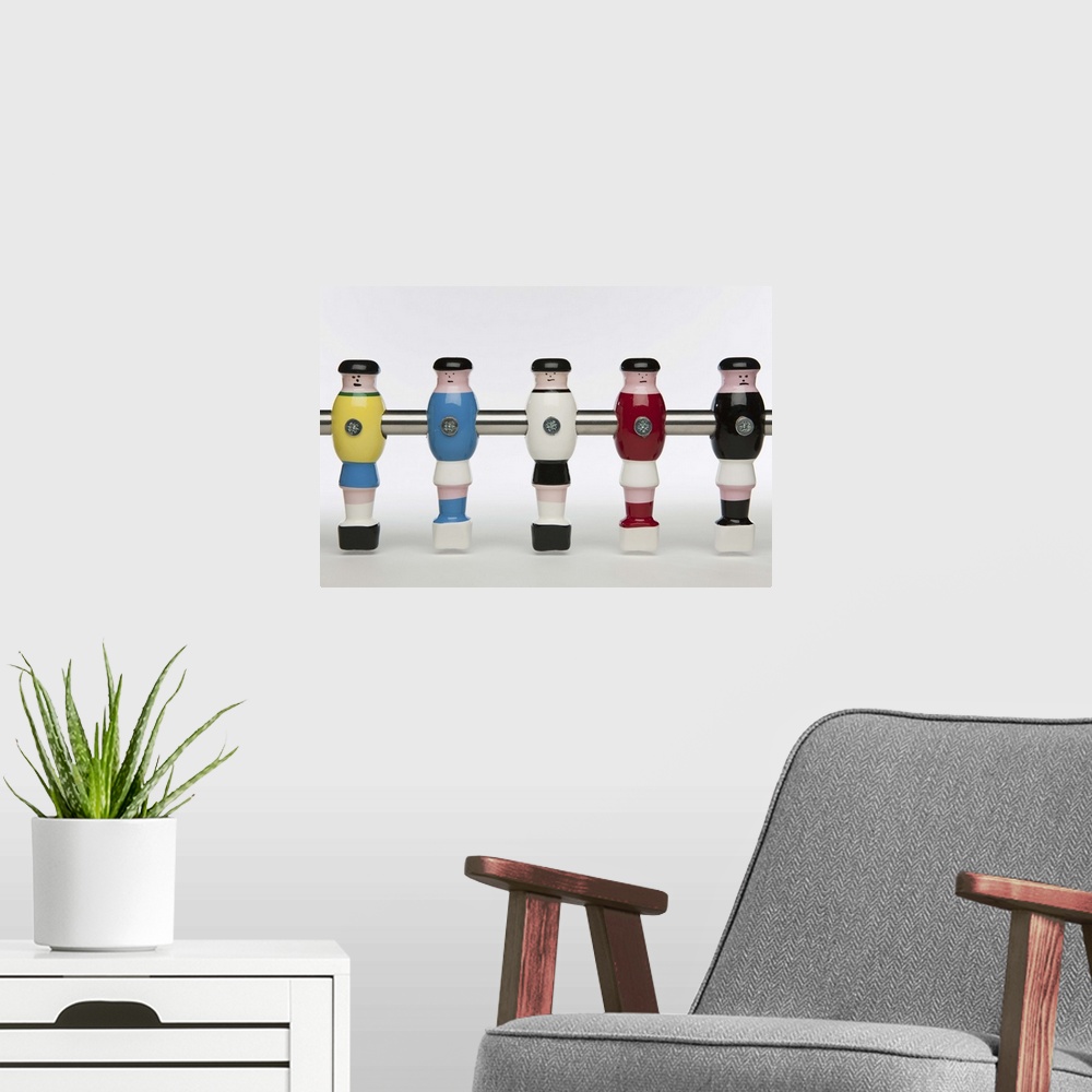 A modern room featuring Five foosball figurines wearing different uniforms