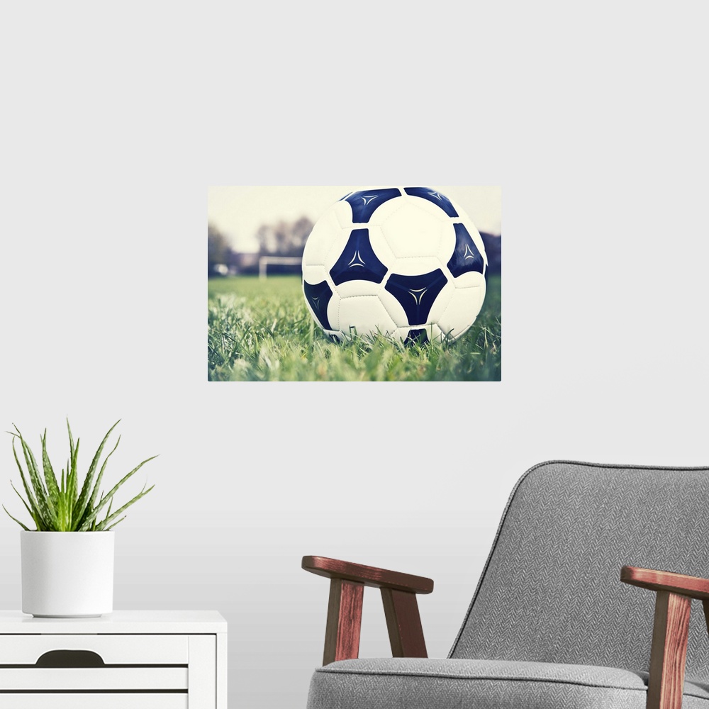 A modern room featuring Football on football pitch with goal in distance.