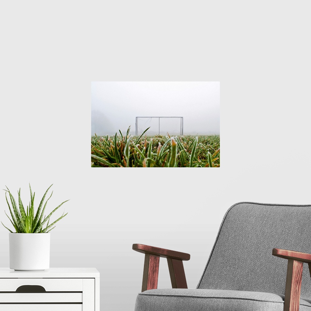 A modern room featuring Frost and fog and football goal on soccer field.