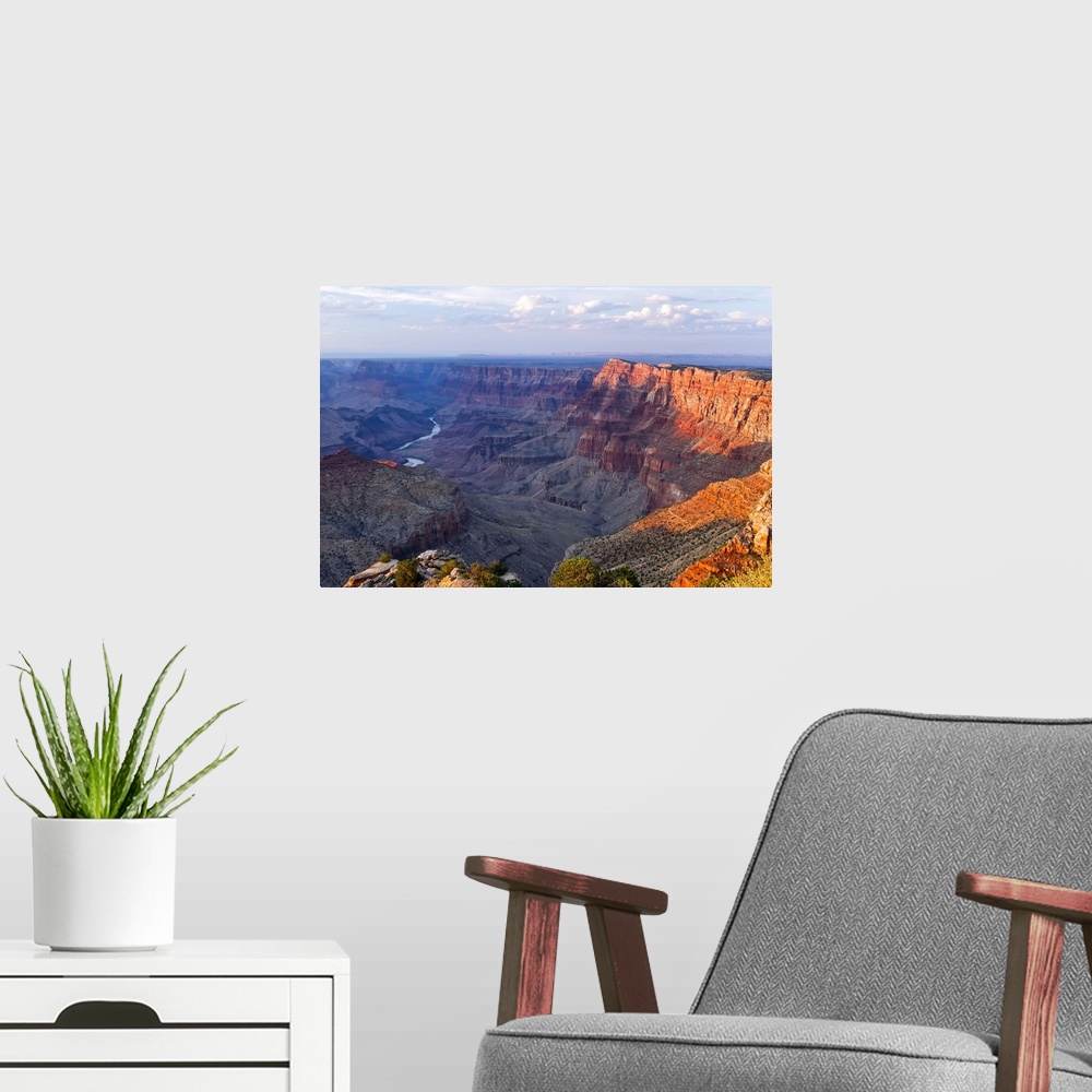 A modern room featuring Landscape, high angle photograph on a big canvas, overlooking the Grand Canyon as the sun sets ov...
