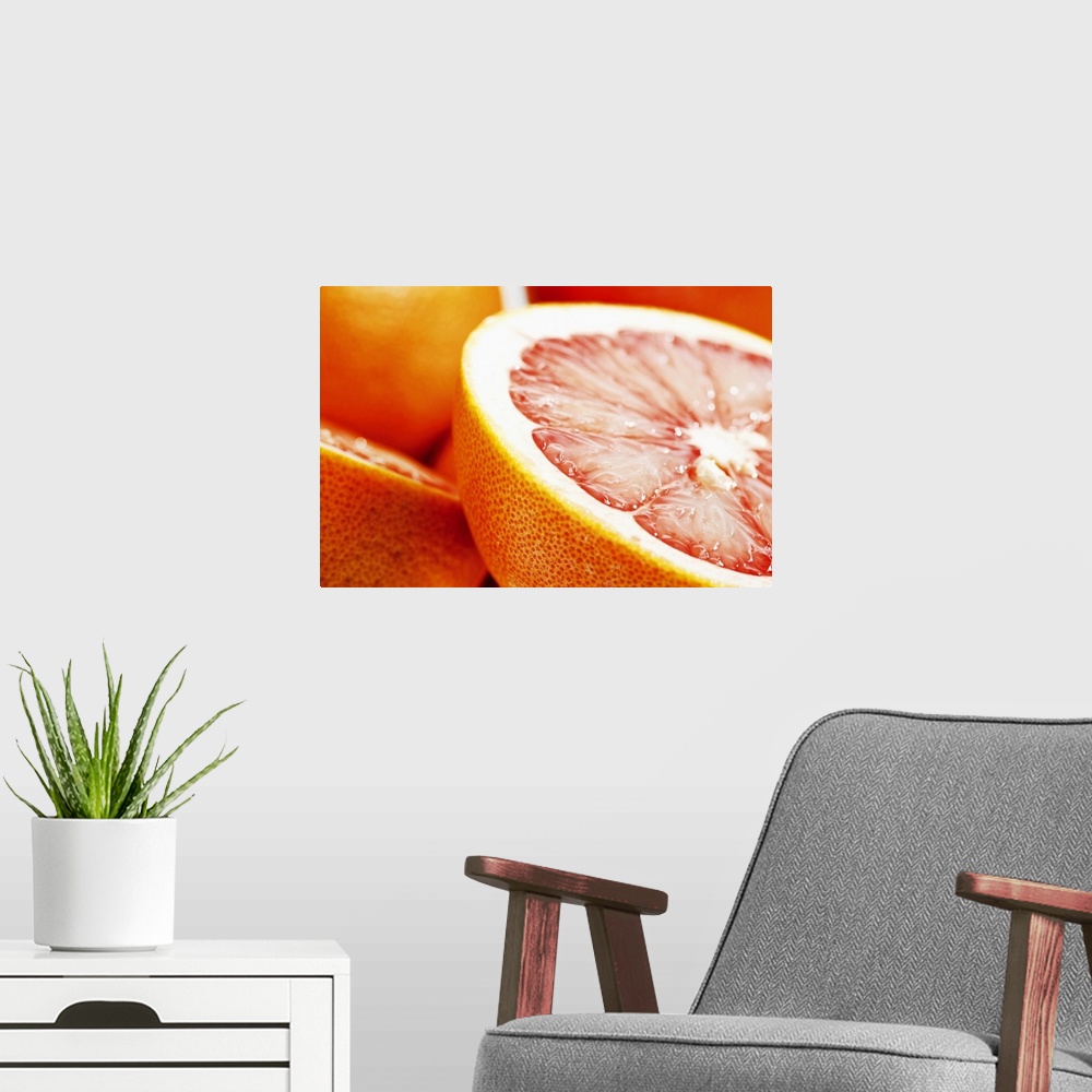 A modern room featuring Big, landscape, close up photograph of a grapefruit, sliced perfectly in half, the other half and...