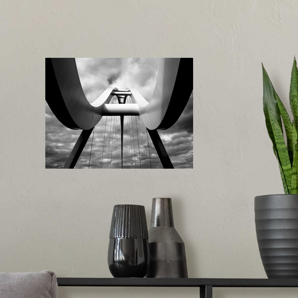 A modern room featuring A black and white photograph taken from below the infinity bridge in the UK and looking up to the...
