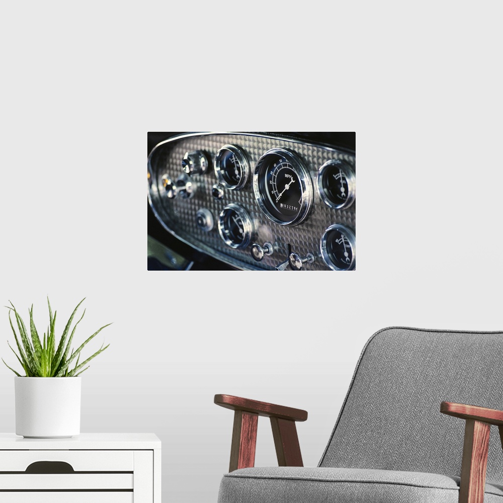 A modern room featuring Horizontal, close up photograph on a big canvas of a chrome and black, rounded instrument panel o...