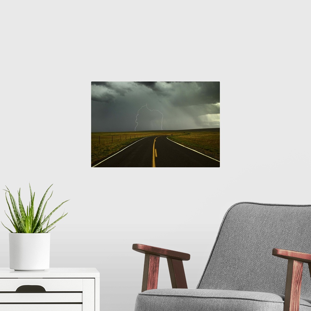A modern room featuring Long and winding road against lighting strike in sky in Santa Fe Trail, Watrous, New Mexico.