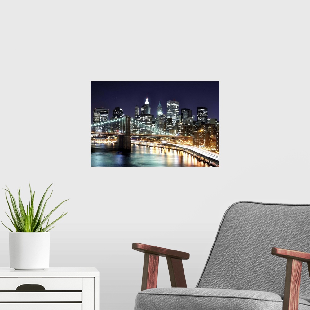 A modern room featuring Aerial view of lower Manhattan including the financial district and the Brooklyn Bridge at night.