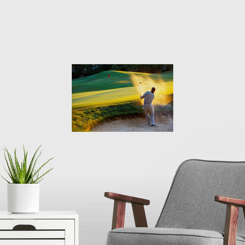 A modern room featuring Man hitting golf ball out of sand trap