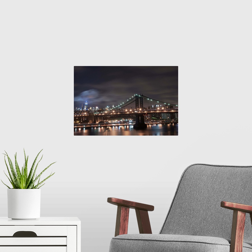 A modern room featuring Night time long exposure taken from the Brooklyn Bridge facing uptown looking at the Manhattan Br...