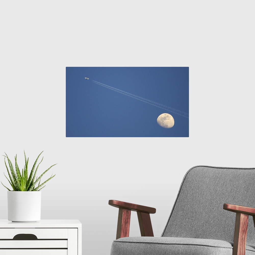 A modern room featuring Moon and airplane in sky.