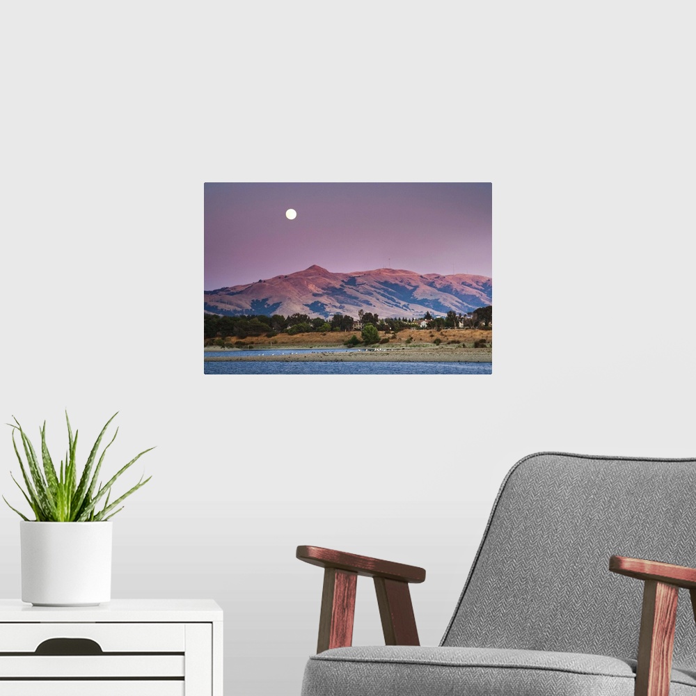 A modern room featuring Moonrise Over Mission peak California at sunset time.