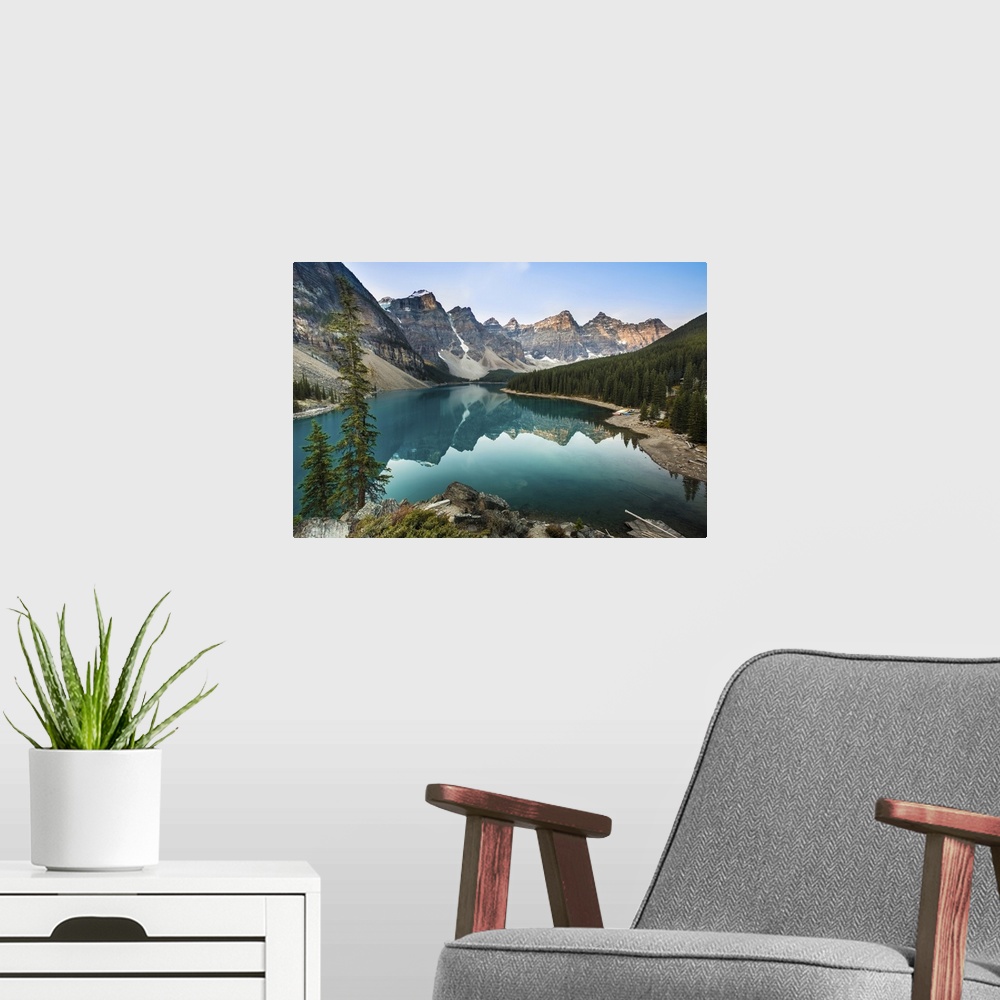 A modern room featuring Moraine Lake right after sunrise time, sun light adds red color to the peaks around with reflecti...