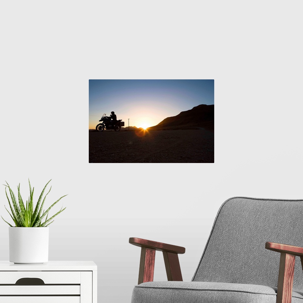 A modern room featuring Motorcyclist riding at sunset