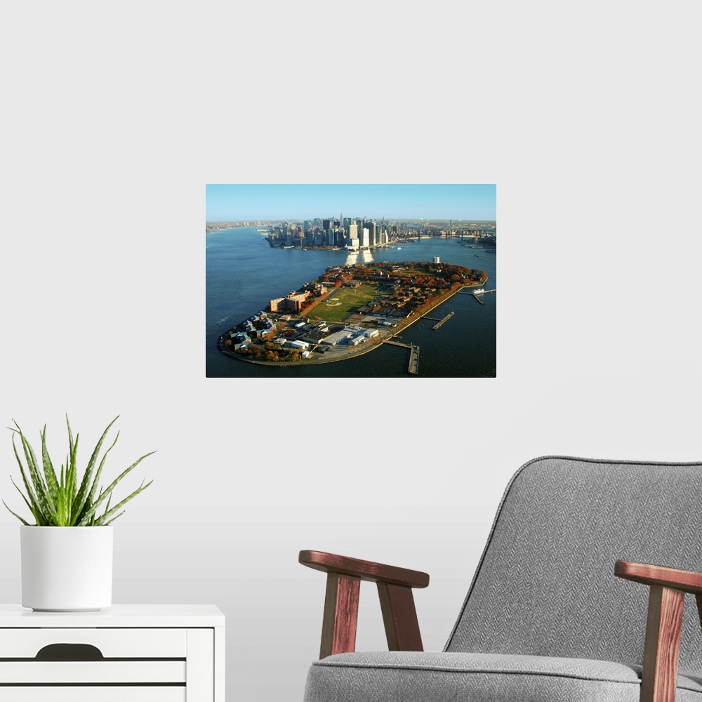 A modern room featuring New York Harbor and Manhattan  with Governors Island in the foreground.