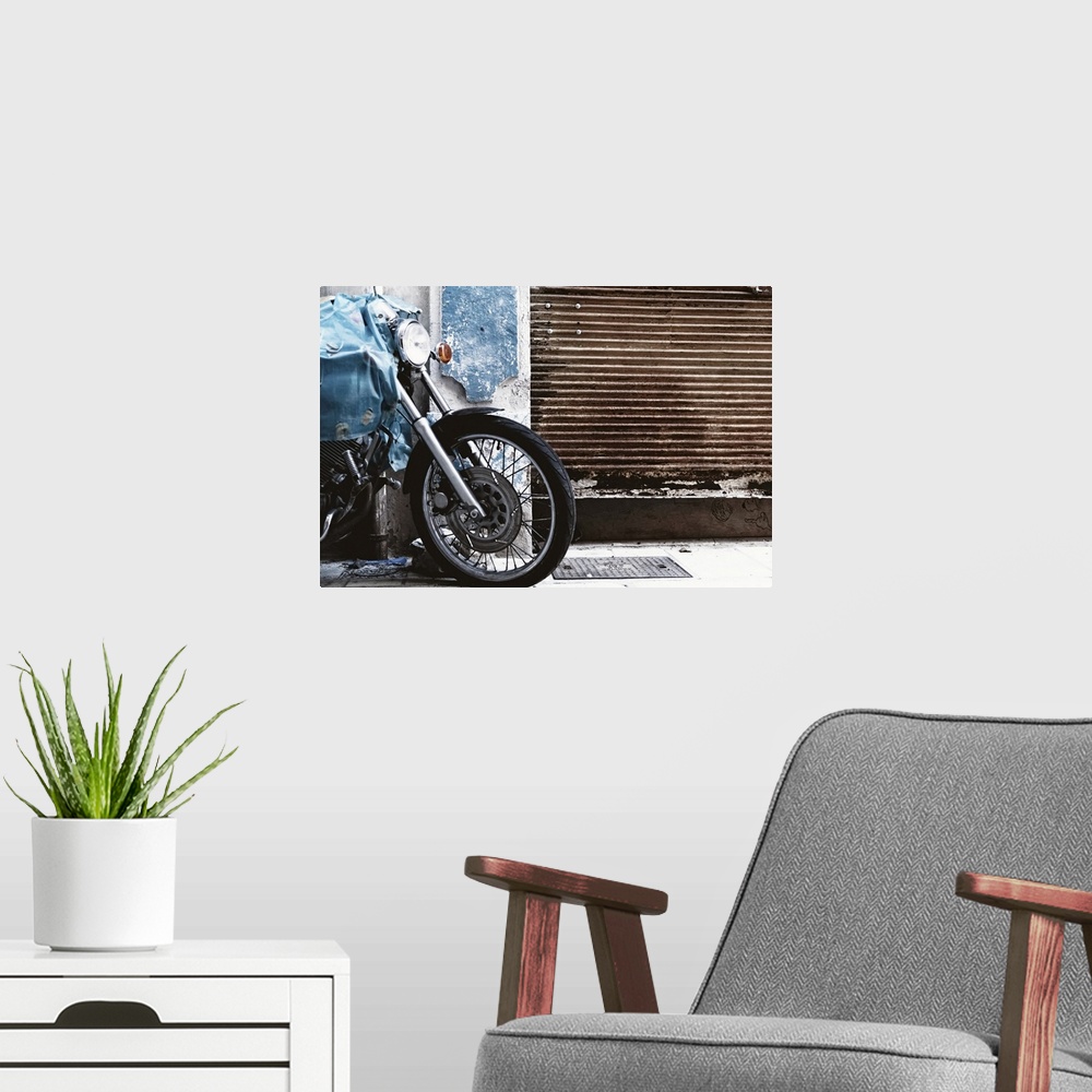 A modern room featuring Parked motorcycle with rusty garage door.