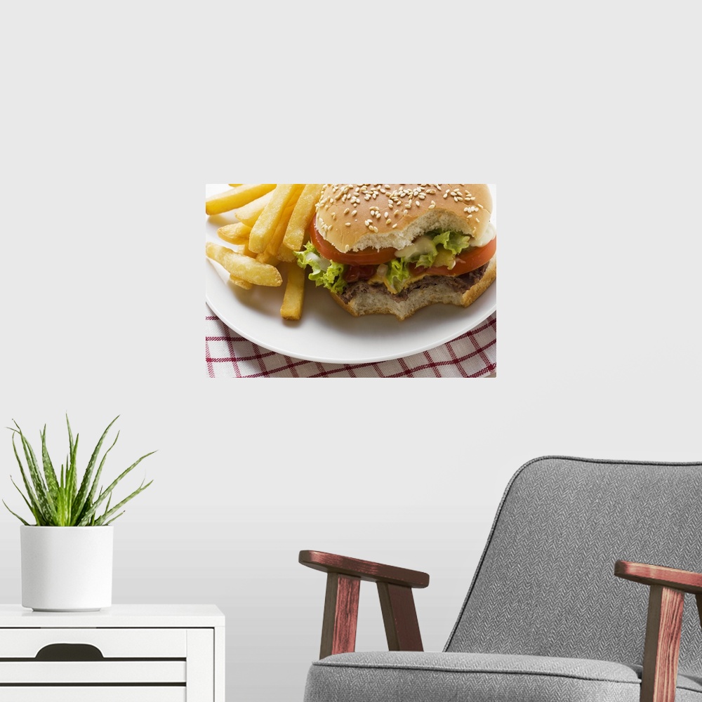 A modern room featuring Cheeseburger, bites taken, with chips