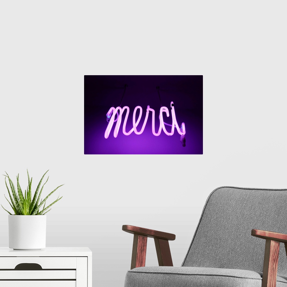 A modern room featuring Pink and purple Neon light sign saying merci (thanks in french).